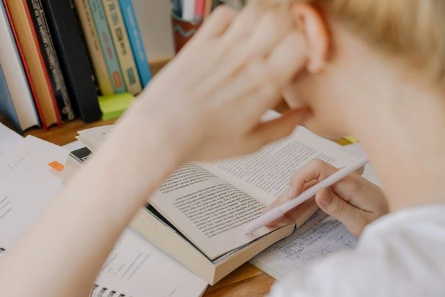 Estudante organizando materiais e revisando conteúdos em uma mesa de estudos